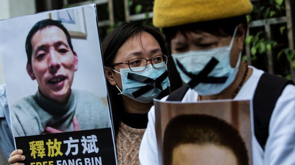 An activist holds a placard of missing citizen journalist Fang Bin, as she protests outside the Chinese liaison office in Hong Kong in 2020