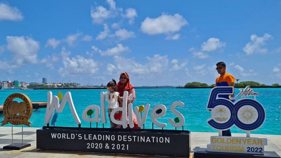 Tourists pose for pictures at the Velana International Airport in Male on July 14, 2022.