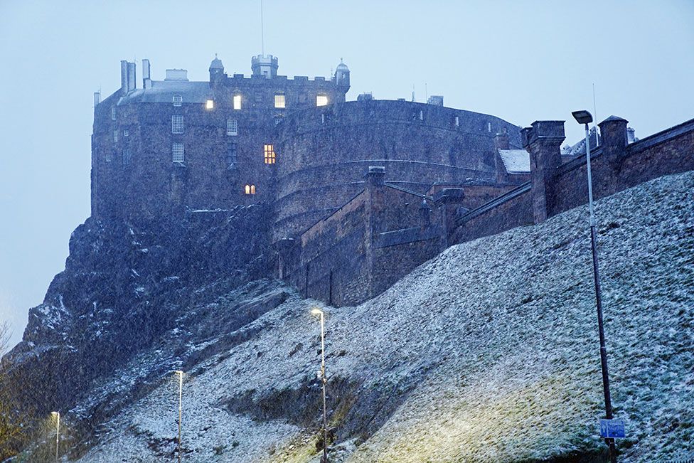 Снег выпадает в Шотландии на фоне Эдинбургского замка, когда шторм Юнис проносится по Великобритании 18 февраля 2022 г.