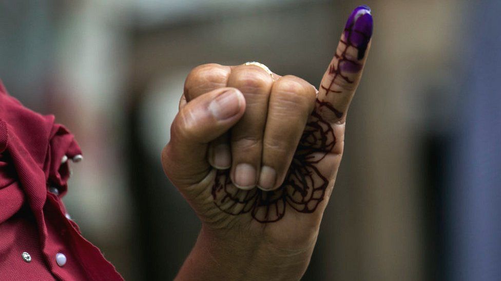 После голосования женщина поднимает накрашенный палец