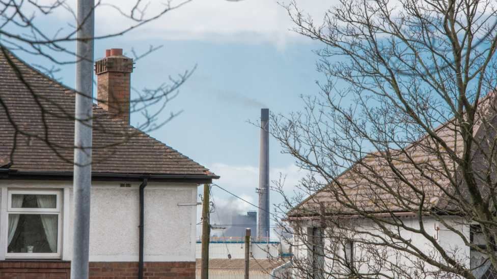 The steelworks as seen through a gap between two houses