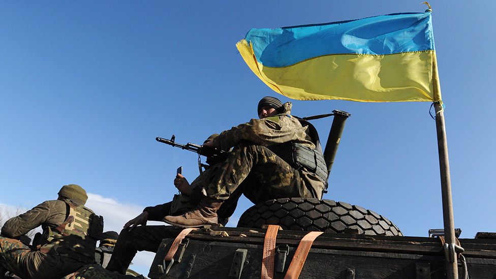 A tank driver flies the Ukraine flag