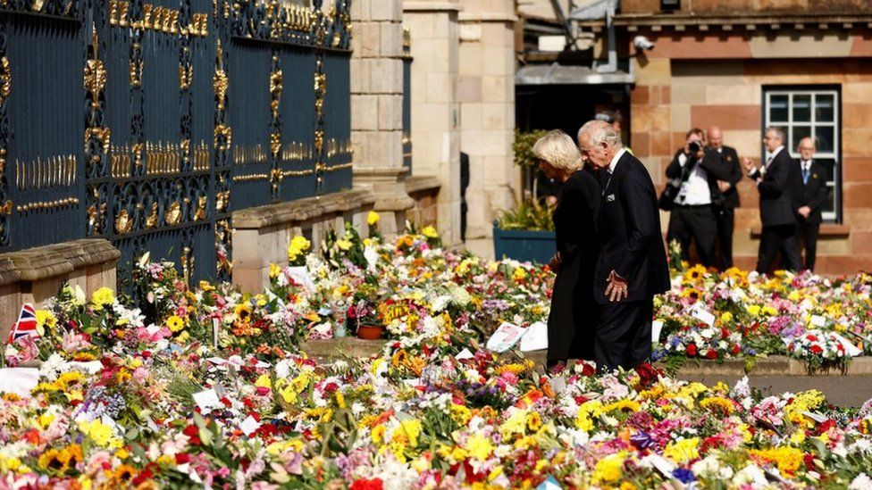 King Charles and Camilla look at the thousands of floral tributes left at the gates of Hillsborough Castle in honour of Queen Elizabeth II
