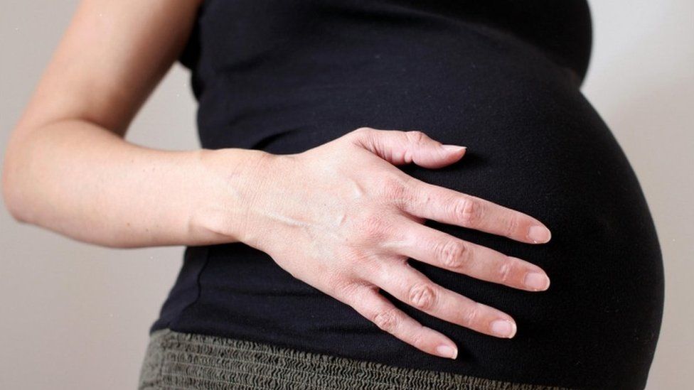 Pregnant woman holding her stomach