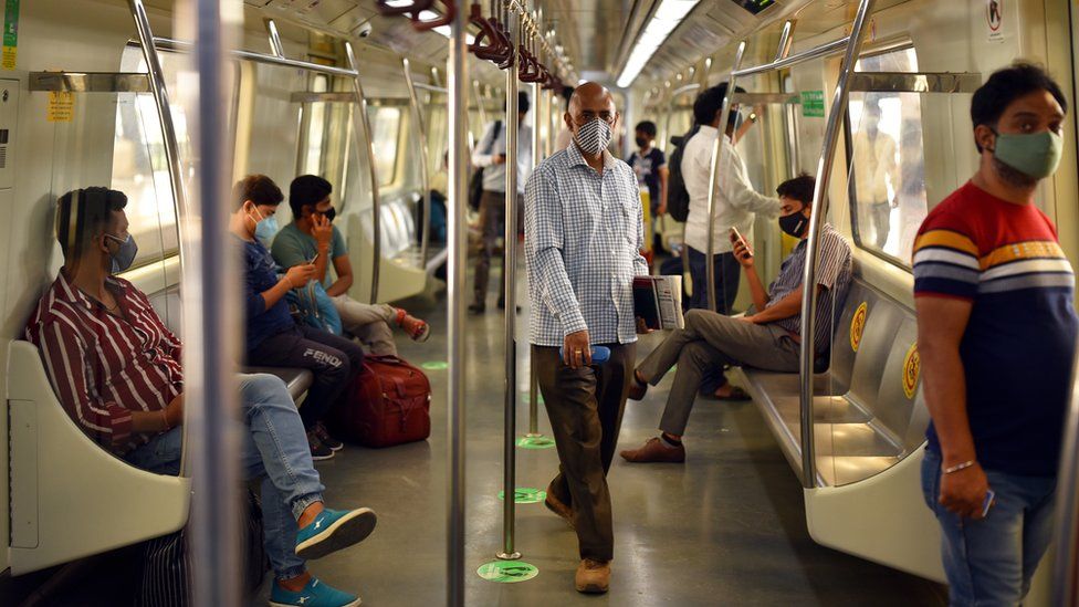 Indian commuters resume travelling on a metro train in Delhi