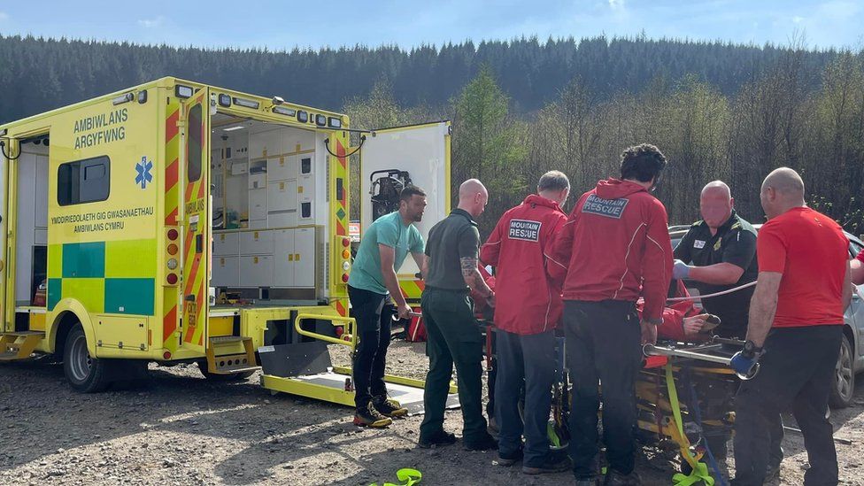 Mountain rescue volunteers helping paramedics treat a person