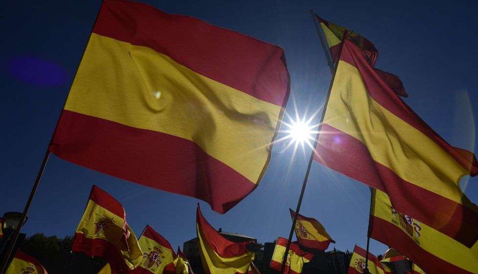 People wave Spanish flags during a demonstration calling for unity in Madrid on October 28, 2017,