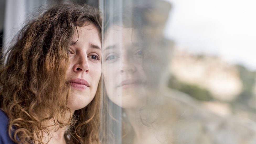 Young woman gazing out of a window