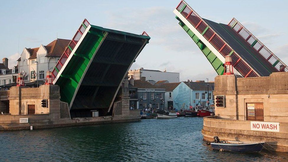 Town bridge raised to allow a yacht to pass into the marina in Weymouth