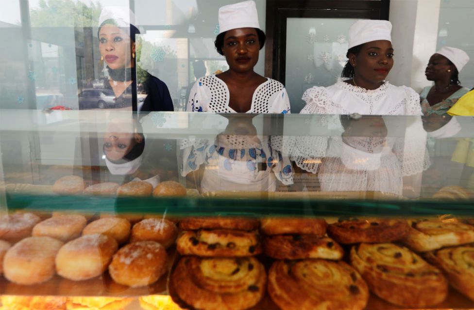 Vendors stand behind a display of pastries at O'Merveilles in Touba, Senegal, on 10 June.