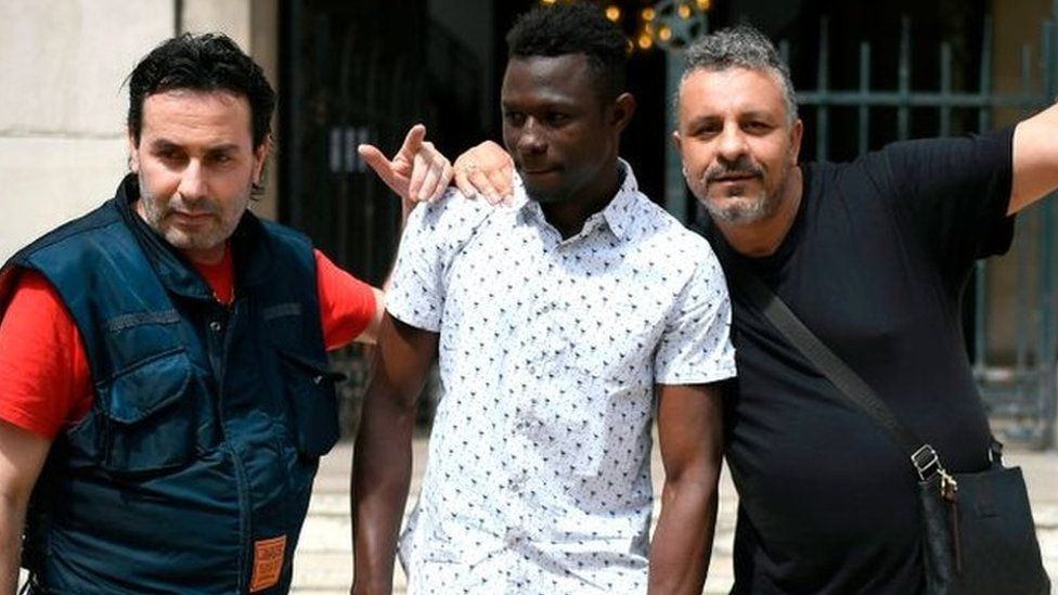 A 22-year old Mamoudou Gassama from Mali (C) poses with passers by in front of the townhall of Montreuil, eastern Paris suburb, on May 28, 2018