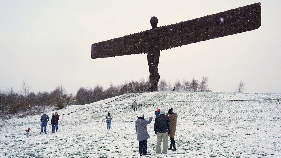 People at a snow covered Angel of the North in Gateshead.