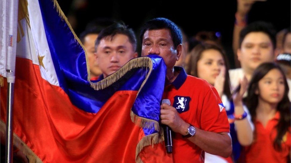 Rodrigo Duterte kisses a Philippines flag in Manila (7 May 2016)