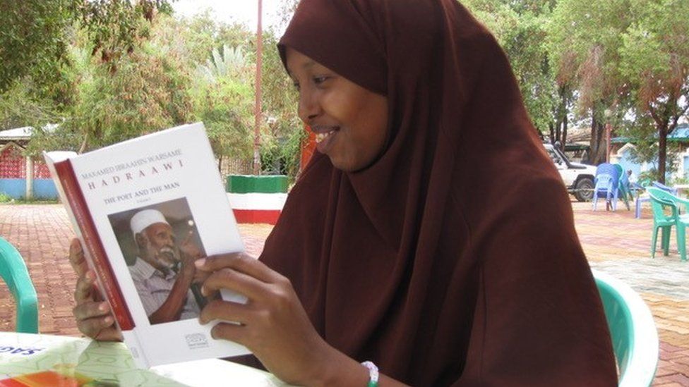 A woman reading a book on Hadraawi