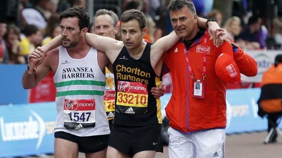 Matthew Rees of Swansea Harriers helping an ailing David Wyeth of Chorlton Runners