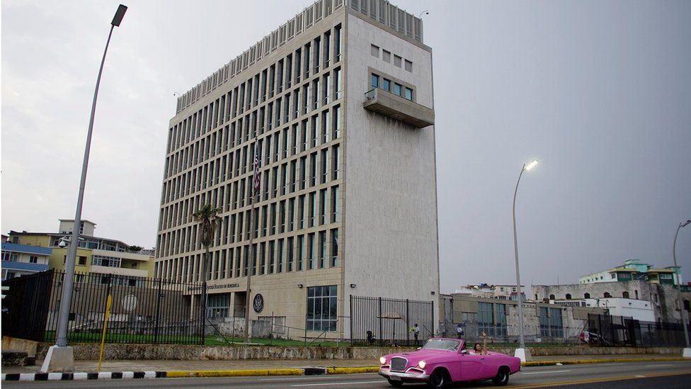 A car with tourists drives past the US Embassy in Havana