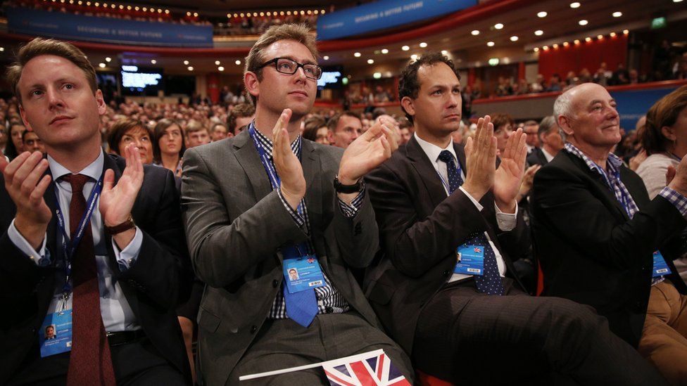 Conservative Party members sit in the audience at party conference