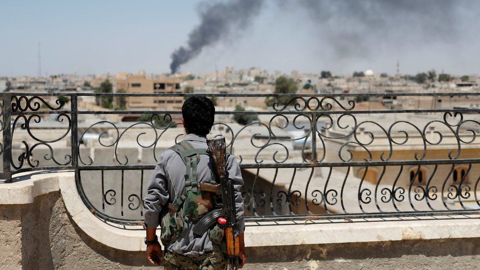 A Kurdish fighter from the People's Protection Units (YPG) looks at a smoke after an coalition airstrike in Raqqa, Syria in June 2016