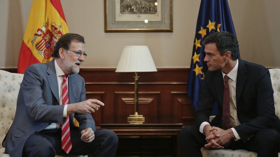 Spanish acting Prime Minister Mariano Rajoy (L), speaks with Socialist party leader, Pedro Sanchez (R),