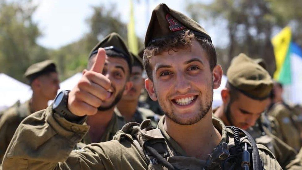 Young man in uniform with beard giving thumbs up