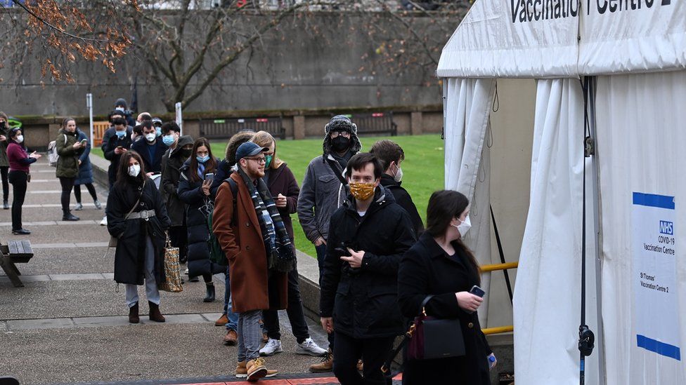 People queue up for Covid-19 booster jabs outside a vaccination centre in London, Britain, 07 December 2021. According to US and UK health experts the Omicron variant is likely to become the dominant variant across Britain.