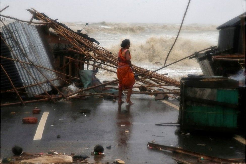 A woman stands next to her stall damaged by heavy winds at a shore ahead of Cyclone Yaas in Bichitrapur in Balasore district in the eastern state of Odisha India, May 26, 2021.