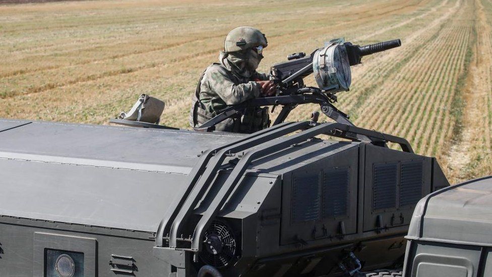 An armed Russian serviceman on a military vehicle keeping watch in a field near Melitopol, Zaporizhia region, southeastern Ukraine, 14 July