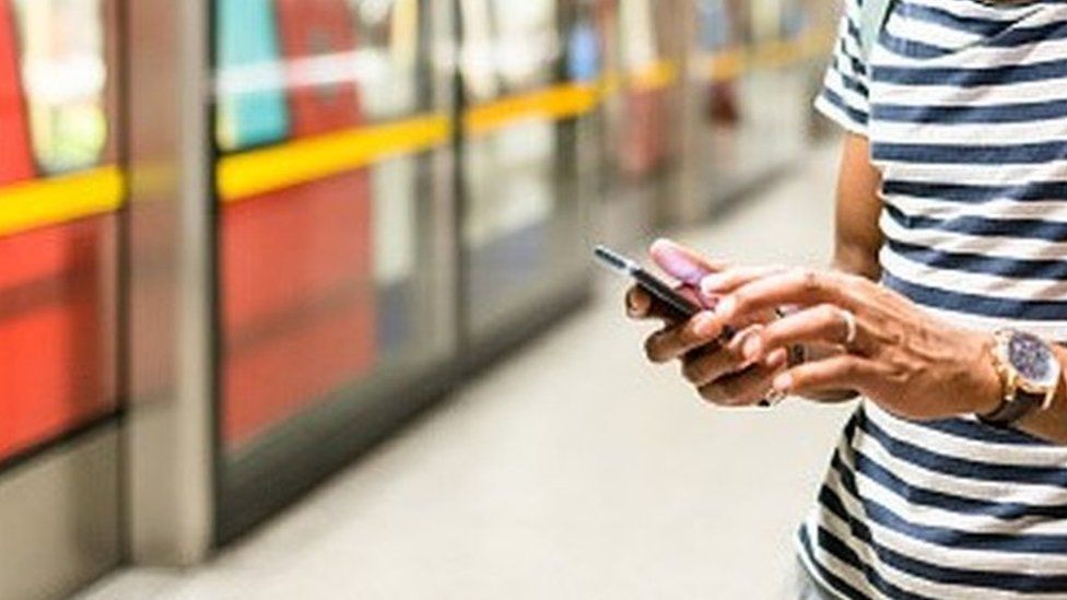 Mobile phone being used on Tube