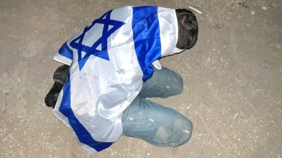 Palestinian detainee is pictured with an Israeli flag draped over their back