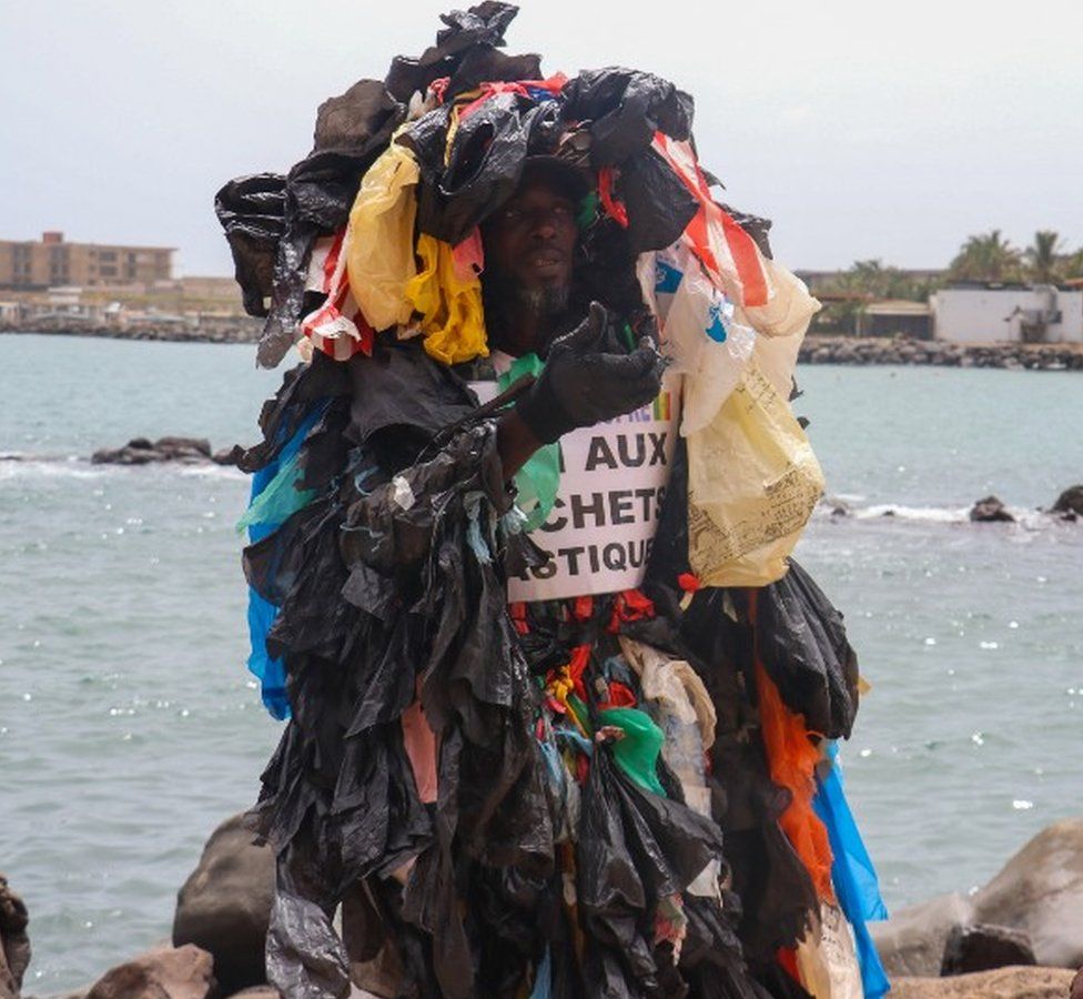 Senegal's plastic man Modou Fall, wearing an outfit made of plastic bags, walks around the city to raise awareness on the plastic waste in Dakar, Senegal on August 16, 2021