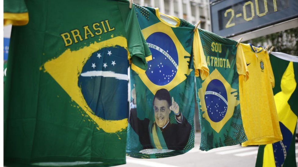 Флаги и рубашки президента Жаира Болсонару в районе Копакабана в день президентских выборов 2 октября 2022 года в Рио-де-Жанейро, Бразилия.