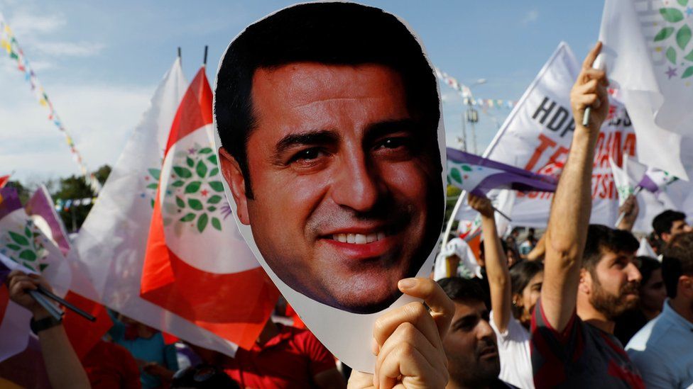 A supporter of Turkey's main pro-Kurdish Peoples' Democratic Party (HDP) holds a mask of their jailed former leader and presidential candidate Selahattin Demirtas