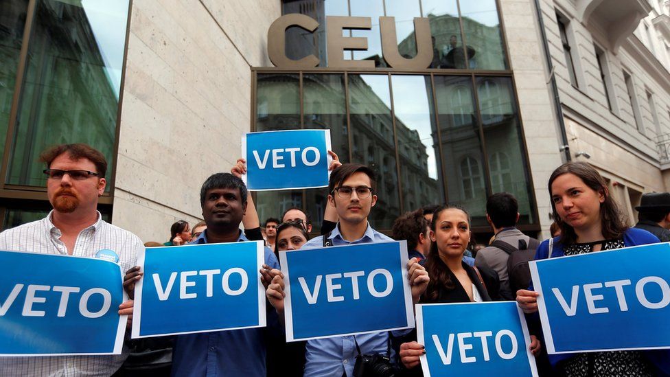 Demonstrators hold up a banner saying "Veto" during a rally against a new law passed by Hungarian parliament which could force the Soros-founded Central European University out of Hungary, in Budapest,