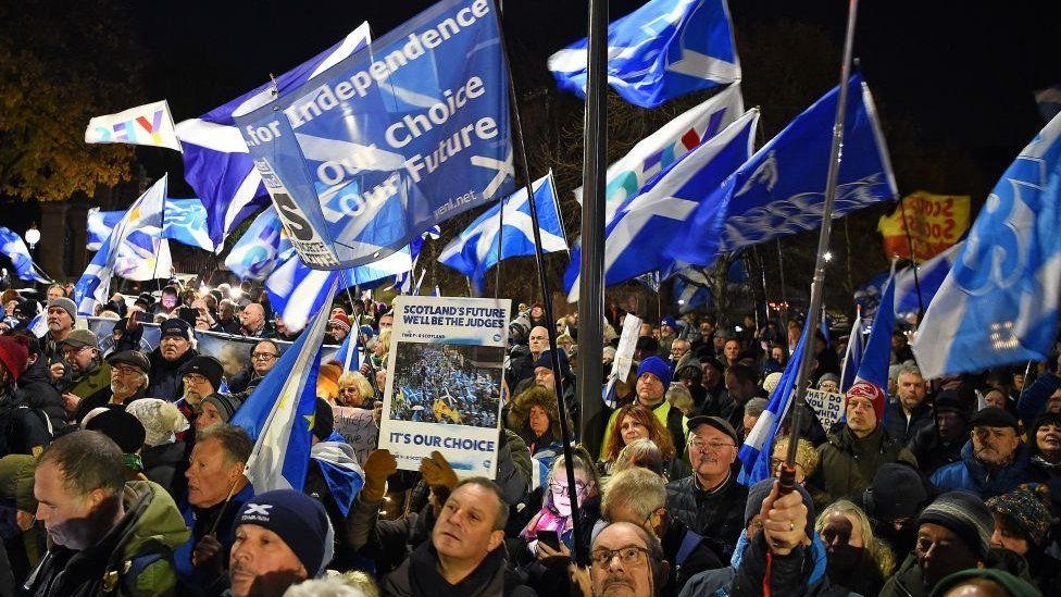 Pro-Scottish independence supporters wave Saltire flags during a rally outside parliament in Edinburgh on November 23, 2022