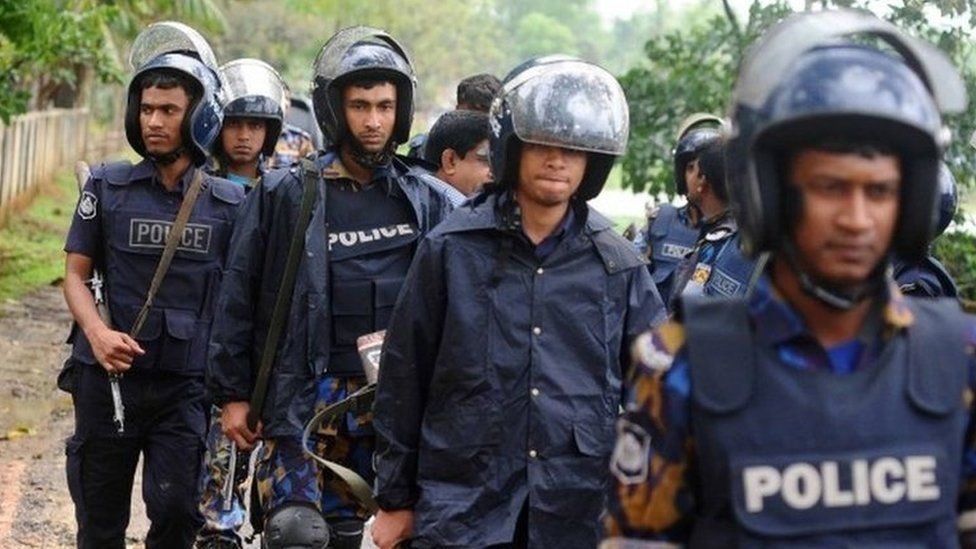 Policemen walk during an operation to storm an Islamist extremist hideout in the town of Moulvibazar on March 30, 2017.