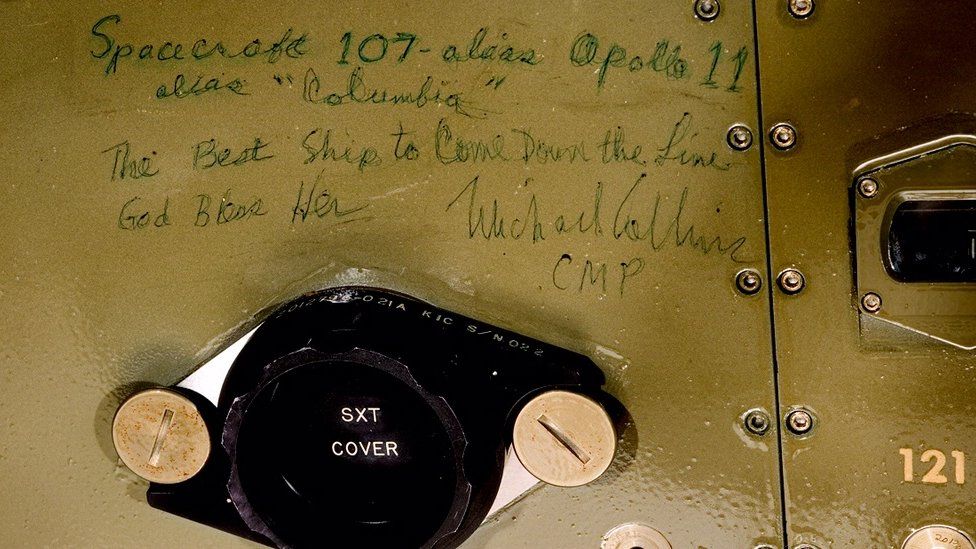The inscription reads: Spacecraft 107, alias Apollo 11, alias "Columbia." The Best Ship to Come Down the Line. God Bless Her. Michael Collins, CMP