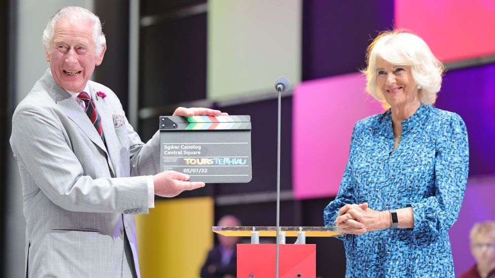 Charles and Camilla with a clapperboard