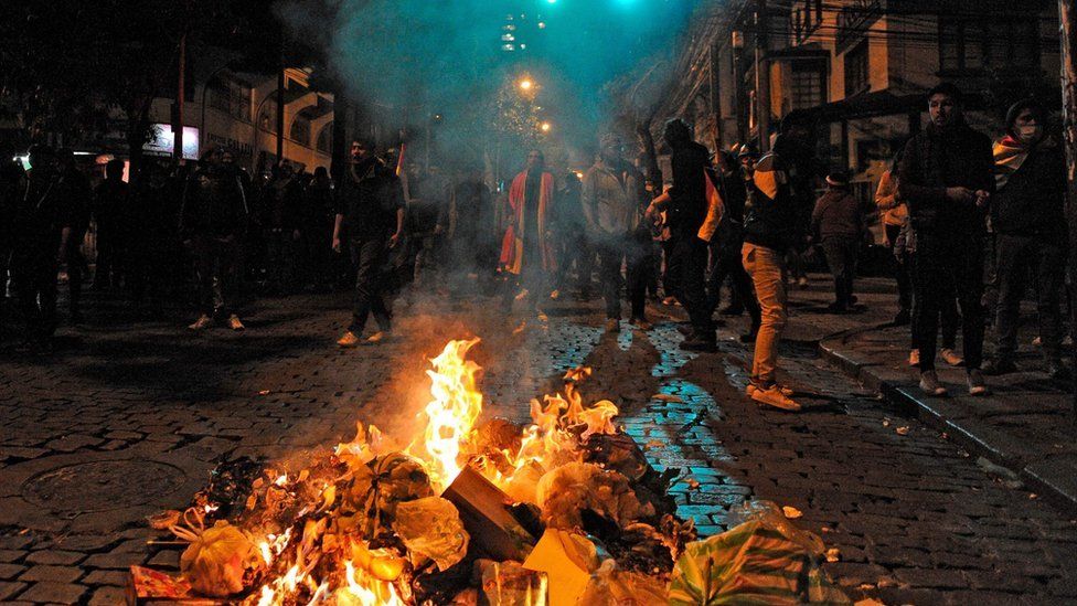 Supporters of the Comunidad Ciudadana opposition party stand behind a bonfire during clashes with police in La Paz