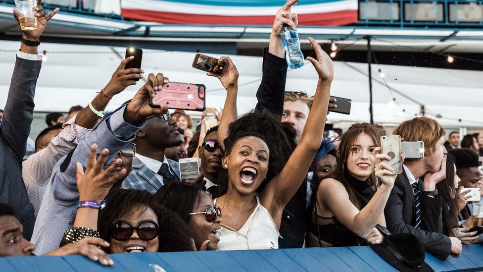 People cheer during the main race of the 2018 edition of the Vodacom Durban July horse race in Durban, on 7 July 2018.