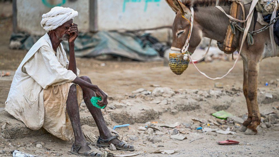 An elderly man waits to refill his donkey-drawn water tank during a water crisis in Port Sudan in the Red Sea State of war-torn Sudan on April 9, 2024