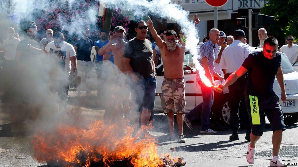 Taxi drivers on strike burn tyres during a national protest against car-sharing service Uber in Marseille, France, June 25, 2015.