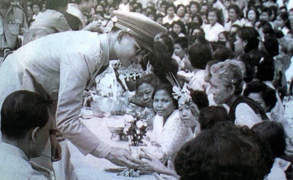 King Bhumibol Adulyadej receives garlands from villagers