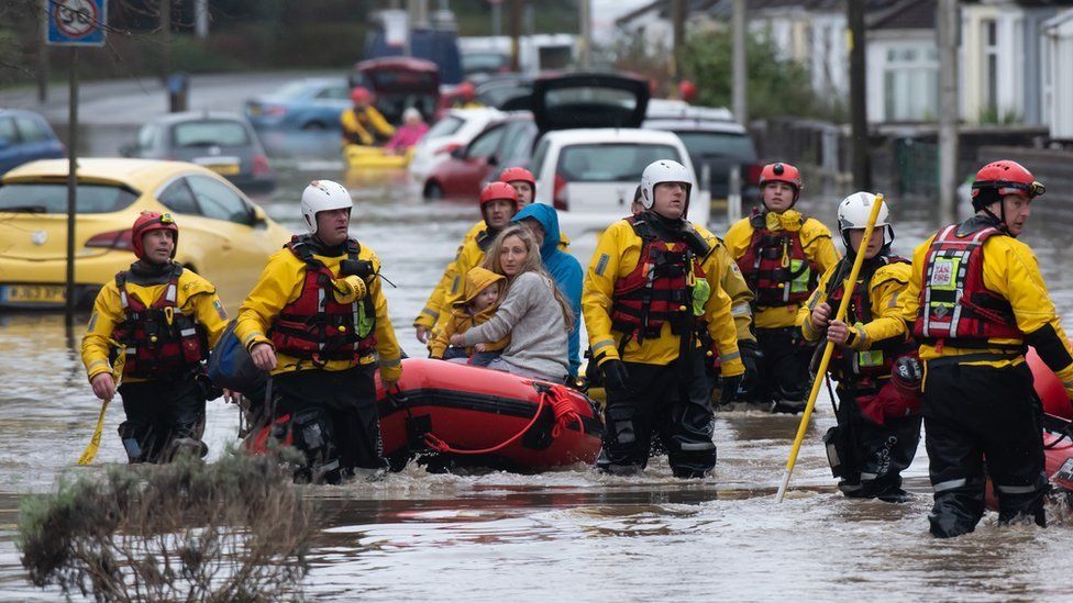 A family is rescued from floodwater in Nantgarw by boat