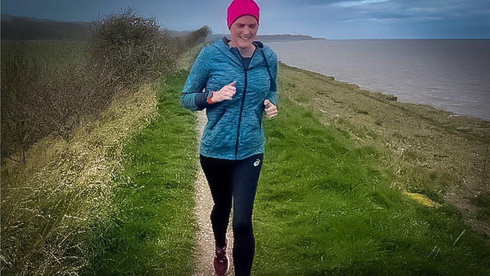 Gayle Redman running along a seaside trail