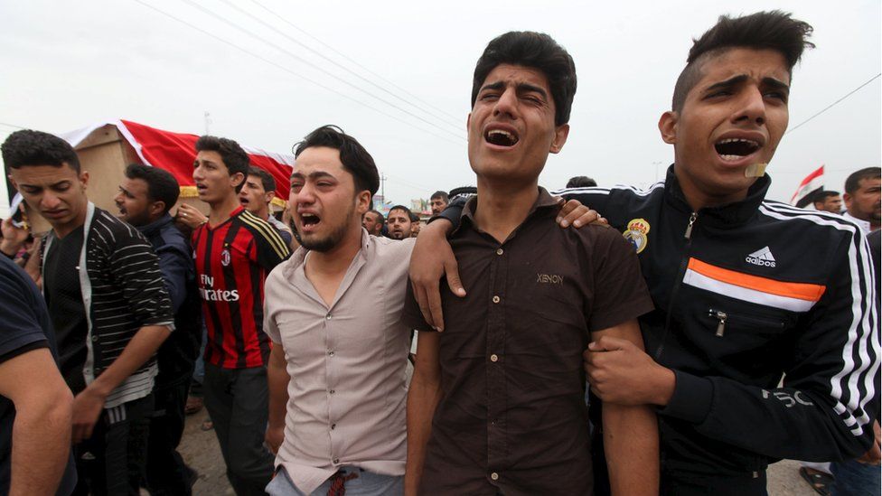 Mourners attend the funeral of a victim killed by a suicide bombing at a soccer field in Iskandariya