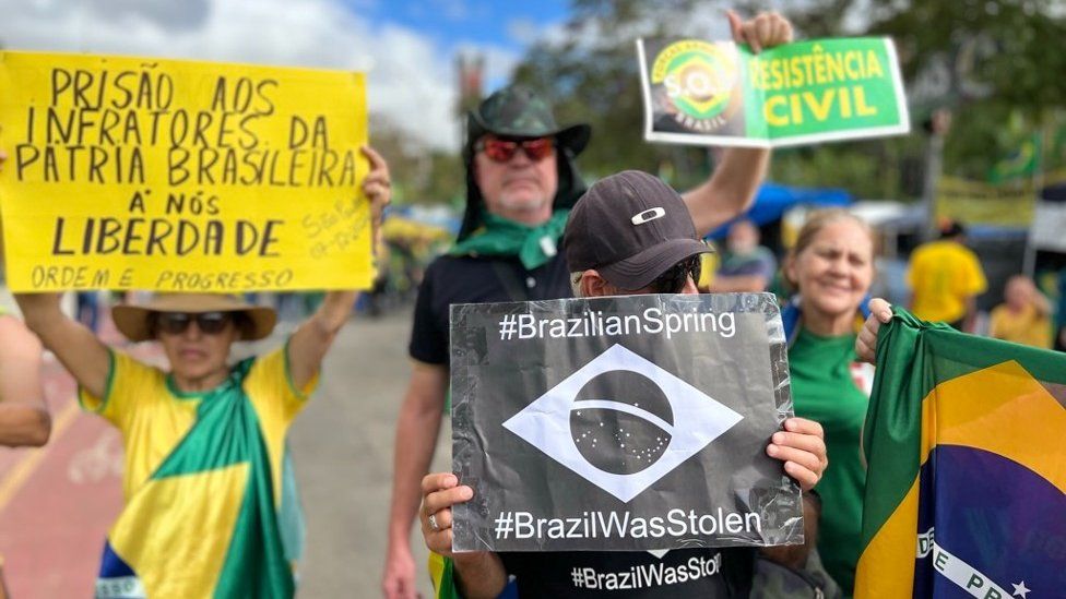Protesters hold up signs in São Paulo