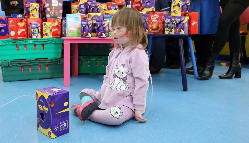 Greta sitting on the floor with an Easter egg