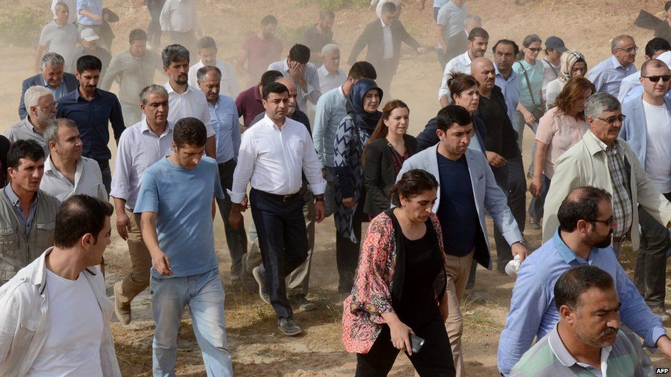 The leader of Turkey's main pro-Kurdish HDP Selahattin Demirtas (C in white shirt) and his delegation cross through a field after the road leading to Cizre was blocked by the Turkish security forces in Sirnak (9 Sept 2015)