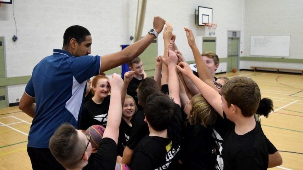 Glasgow Rocks' Kieron Achara with young basketball players