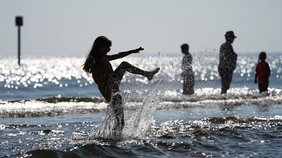 Kadie Lane,10, splashes in the sea at Blyth in Northumberland, as people enjoy the late August bank holiday sunshine.